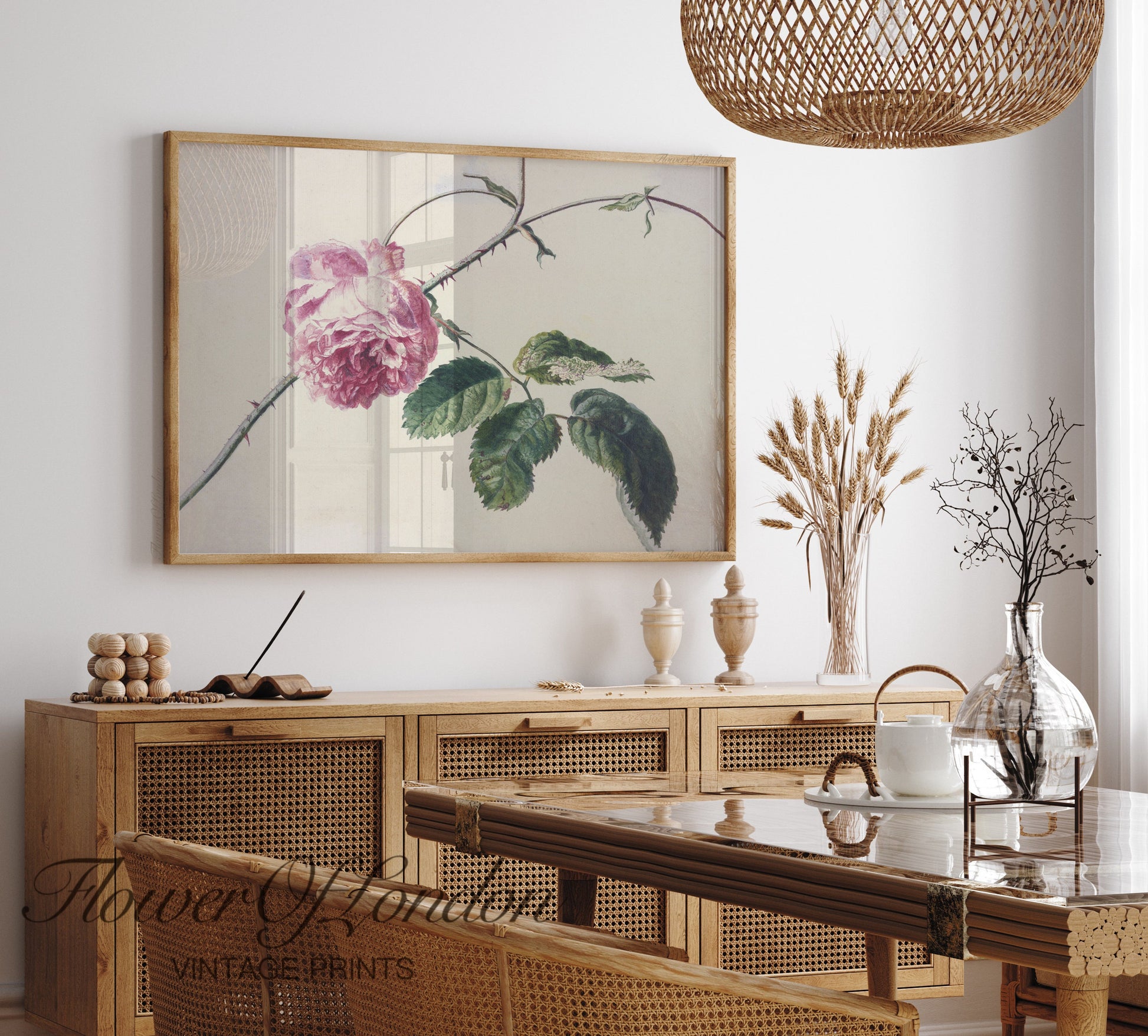 a picture of a pink flower hangs above a dining room table